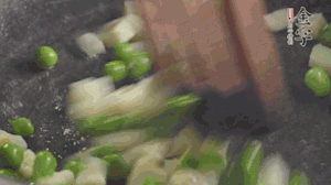 鍋中油7成熱時，入青豆、筍丁翻炒，然后加糯米飯加鹽均勻翻炒。