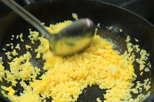 大火加熱炒鍋，再入油，燒到四至五成熱時(shí)倒入雞蛋液，在未凝結(jié)之前，加米飯煸炒，不停翻炒并用鍋鏟將成塊的米飯碾開(kāi)、撥散。