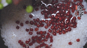 將炒好的食材和大米、紅豆一起放進(jìn)電飯鍋煮。