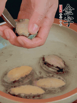 鮑魚加鹽、清水浸泡，用勺子挖出鮑魚肉。