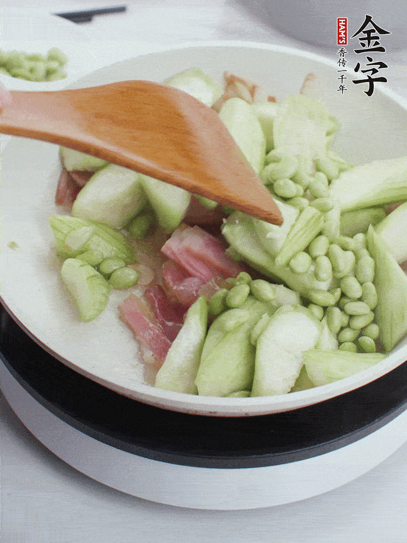 依次下絲瓜、青豆翻炒，炒至絲瓜打蔫縮小。