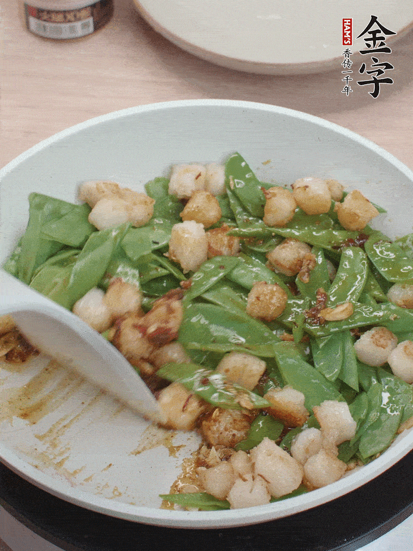 下甜豆莢、鮮貝輕輕翻炒均勻。