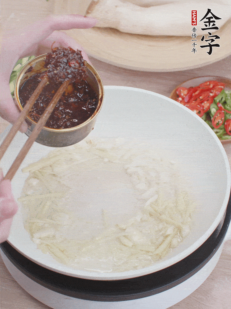 起鍋熱油，姜蒜、金字火腿干貝醬煸香。