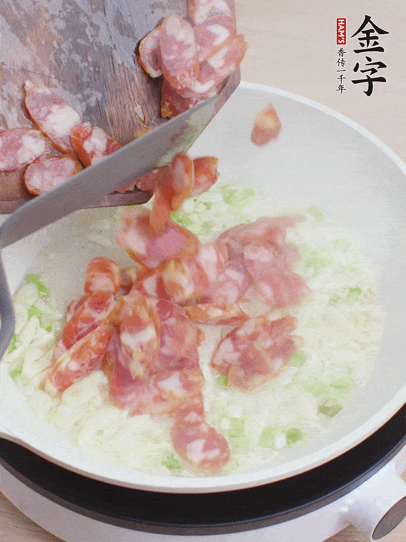 油5成熱，蒜末、蔥白爆香，下香腸炒出香味。