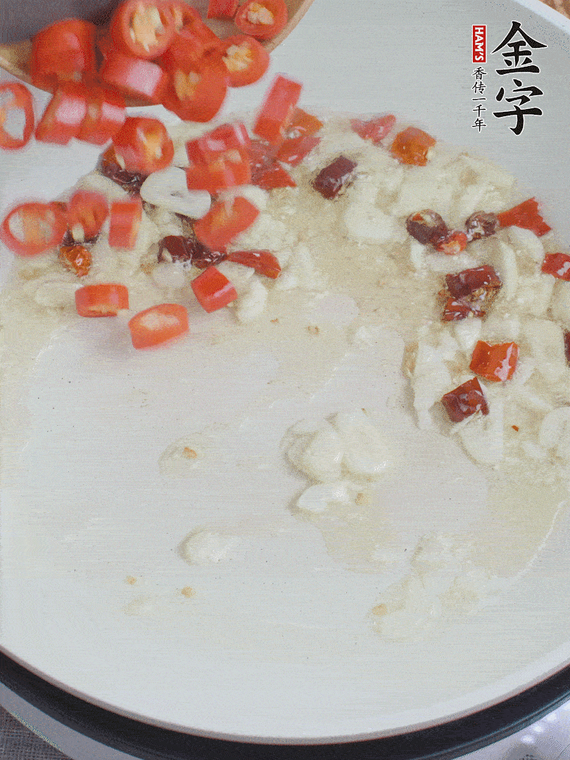 油6成熱，下蒜末、干紅辣椒煸炒，出香味后再放美人椒、香腸。