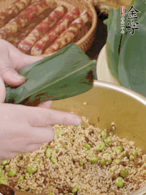粽葉往下折，完全蓋住，兩側(cè)捏緊。