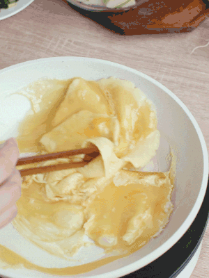 油6成熱時，下雞蛋液，邊緣凝固時翻拌成塊狀。