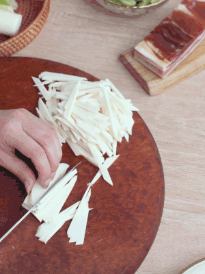 茭白切細(xì)絲，鹽水中浸泡防止氧化。