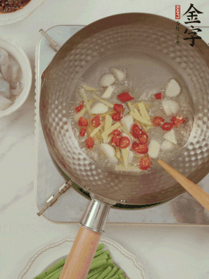 油7成熱時(shí)，下大蒜粒、姜絲、小米辣煸香。