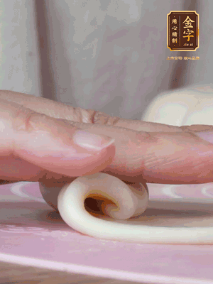 做面劑 油皮按扁，中間包入一個油酥，邊緣收緊捏死。包好的面劑按扁，用搟面杖搟壓成橢圓形。從底部向上卷成筒狀，用保鮮膜蓋好松弛15分鐘，再把筒狀縱向搟壓成長條狀。再卷一次，松弛20分鐘