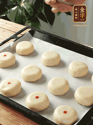 收口向下放在案板上，輕輕將月餅坯按扁，用筷子點(diǎn)紅點(diǎn)做裝飾