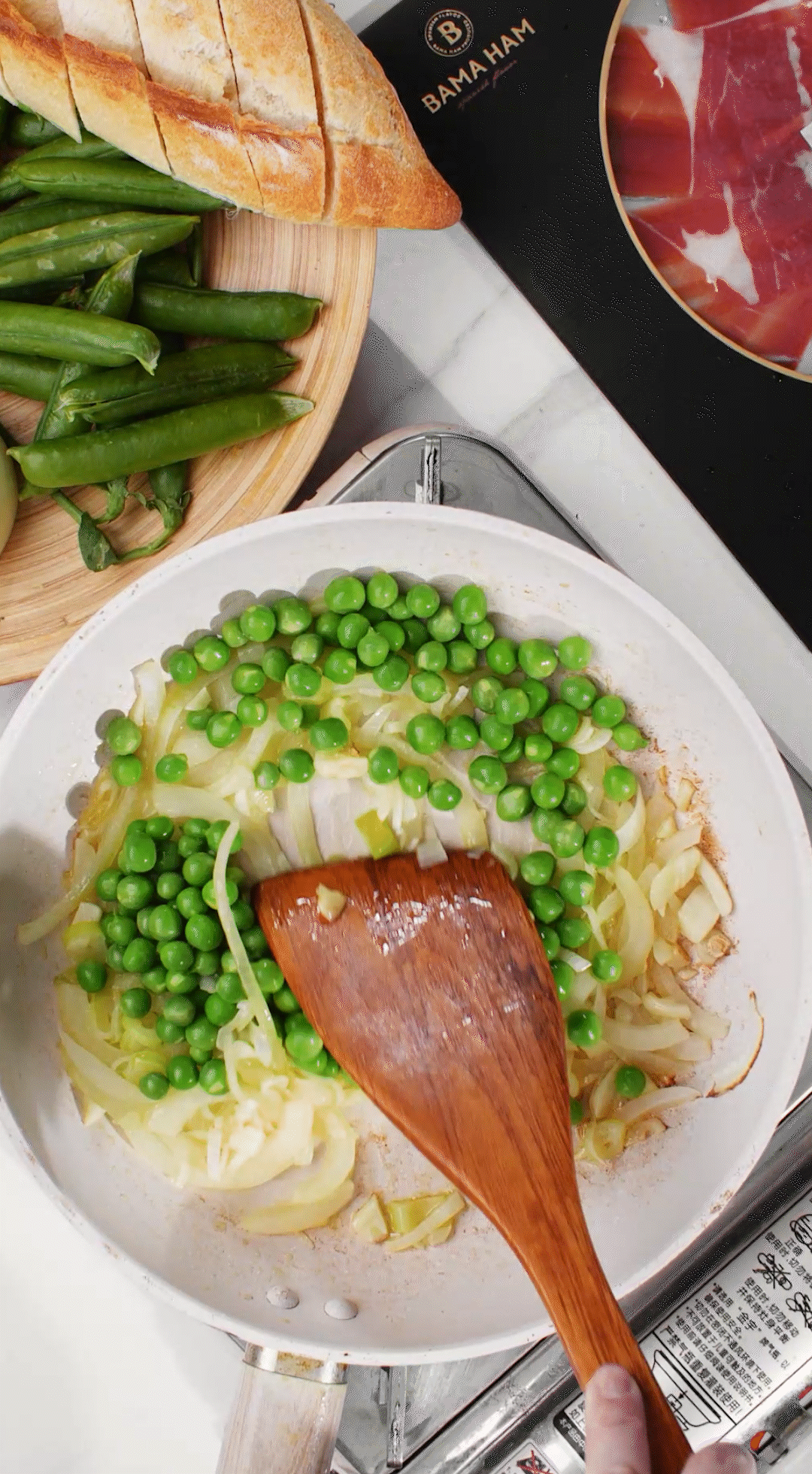 鍋中放入黃油融化，加入洋蔥絲、大蔥蔥白絲、蒜末翻炒變軟出香味。加入剛剛汆燙冰鎮(zhèn)后的豌豆，取出一點(diǎn)點(diǎn)待會(huì)擺盤裝飾用。加一點(diǎn)鹽 (和黑胡椒) 調(diào)味。