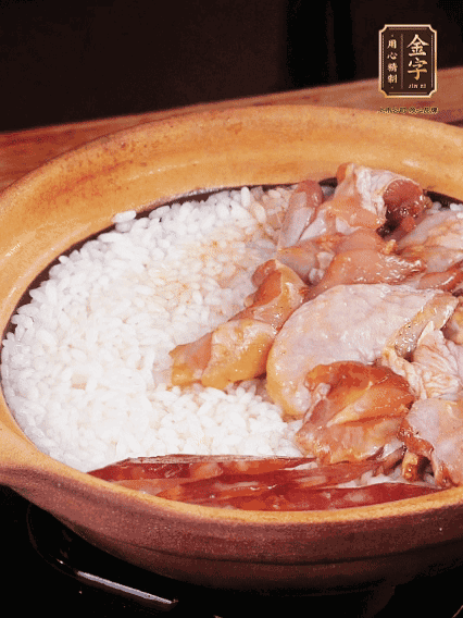 煮到椰子水微微收干轉(zhuǎn)小火，快速均勻鋪上雞肉、金字香腸